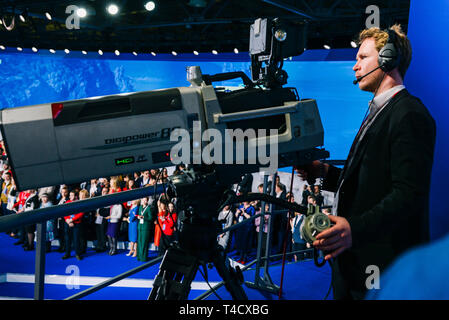 Russia, city Moscow - December 18, 2017: A professional cameraman shoots a crowd of people on the studio camera. High zoom lens to highlight large Stock Photo