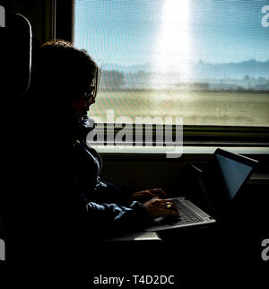 Woman Working on Laptop in Train in Switzerland. Stock Photo