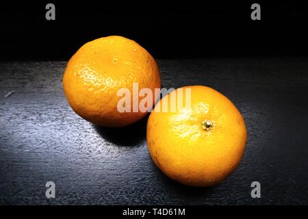 Two fresh oranges on shiny black background. Stock Photo