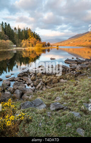 Moody, scenic view of Snowdon Horseshoe mountains at sunrise, in clouds reflected in still water of Llynnau Mymbyr, Snowdonia National Park, Wales, UK. Stock Photo