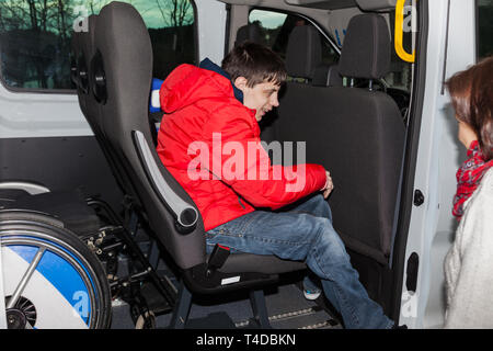 Handicapped boy is picked up by school bus Stock Photo