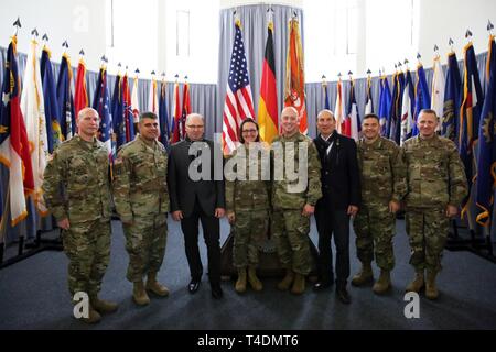 U.S. Soldiers from the 2d Theater Signal Brigade (left), 44th Expeditionary Signal Battalion (center), and U.S. Army Garrison Rheinland-Pfalz (right) command teams, and the district and city mayors of Baumholder, stand for a photo following a ceremony to uncase the 44th Expeditionary Signal Battalion's colors, April 4, 2019, in Baumholder, Germany. The battalion is relocating from Grafenwoehr to Baumholder as part of overseas force structure changes resulting from the 2017 National Defense Authorization Act, showing continual U.S. commitment to NATO and its collective defense. Stock Photo