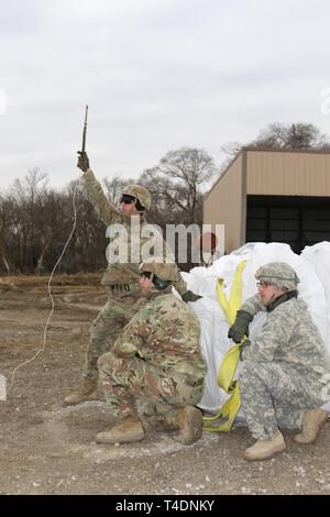 Nebraska Army National Guard Soldiers, Pfc. Kyle Young (left), Spc. Rasmussen (middle) and Pfc. Jacob McCarthy (right) await an inbound UH-60 Blackhawk helicopter during sandbagging operations near Genoa, Nebraska March 23. Nebraska Army National Guard helicopter and ground crews have been conducting sandbag air drop missions in support of the 2019 flooding. (Nebraska National Guard Stock Photo