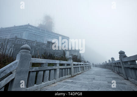 Architecture structure statue big Buddha in foggy at Fansipan hill Stock Photo