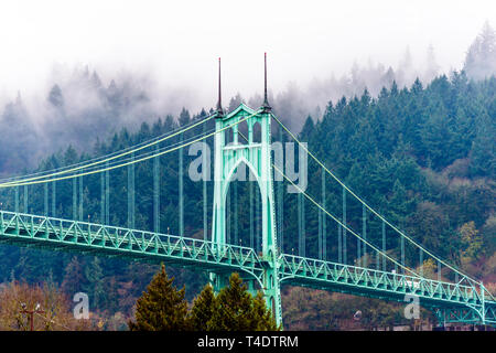The large famous gothic arched transportation and pedestrian St Johns bridge across the Willamette River in Portland Oregon Down Town and trees on a h Stock Photo