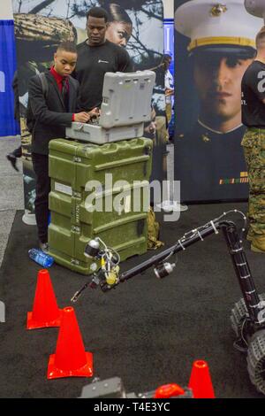 Orosi Abell, a junior at Tennessee State University, operates EOD robot Talon with Staff Sgt. Steven Bellamy, an explosive ordnance disposal technician with 2nd EOD Company, 8th Engineer Support Battalion, during a National Society of Black Engineers conference career fair in Detroit, Michigan, March 29, 2019. NSBE is holding its 45th annual national convention consisting of various programs and workshops that are designed to benefit grade school, collegiate, technical, professional and international attendees and the U.S. Marine Corps is a partner organization. Marines partner with organizati Stock Photo