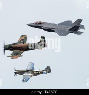 An F-35A Lightning II, Douglas A-1 Skyraider, and P-51 Mustang fly all fly in formation as part of a Heritage Flight during the Melbourne Air and Space Show March 30, 2019, in Melbourne, Fla. The heritage flight display showcases the progression of our nation’s aviation history and represents the past, present, and future of Air Force airpower. Stock Photo