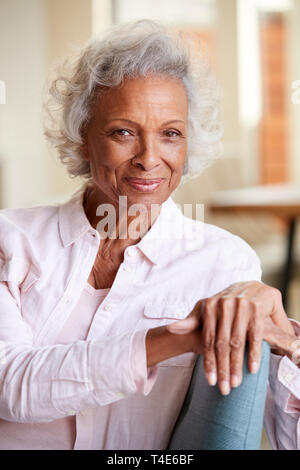 Portrait Of Smiling Senior Woman Relaxing On Sofa At Home Stock Photo
