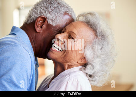 Profile Shot Loving Senior Couple Hugging At Home Together Stock Photo