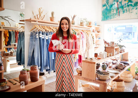 Portrait Of Female Owner Of Independent Clothing And Gift Store With Digital Tablet Stock Photo