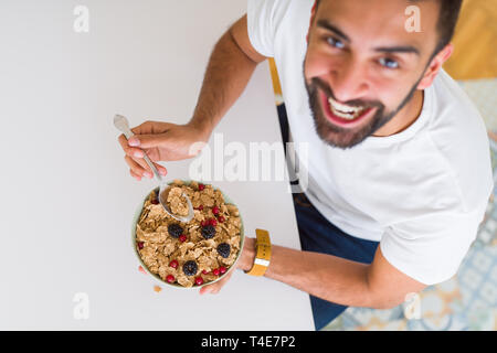 Above angle of handsome man eating healthy cereals for breakfast in the morning Stock Photo