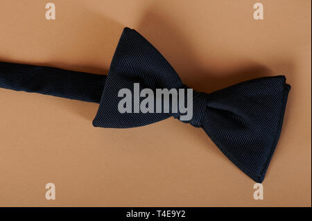 One blue color bow tie on beige color background Stock Photo