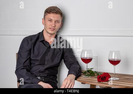 Young handsome man sitting by table in cafe Stock Photo