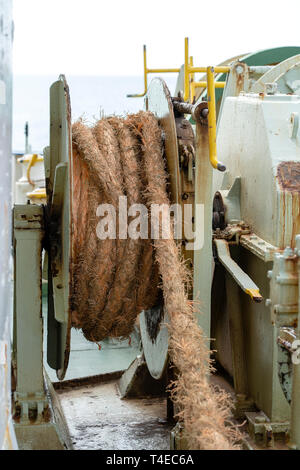 A thick rope is wrapped around a drum on deck of a ferry boat , Thailand. Close up Stock Photo