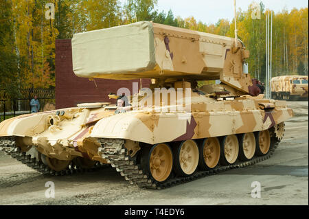 Nizhniy Tagil, Russia - September 26. 2013: Visitors examine military equipment on exhibition range. TOS-1A system fighting vehicle SAolncepek in moti Stock Photo