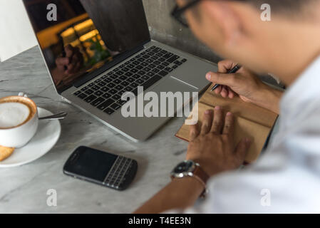 Side view of young man writing notes Stock Photo