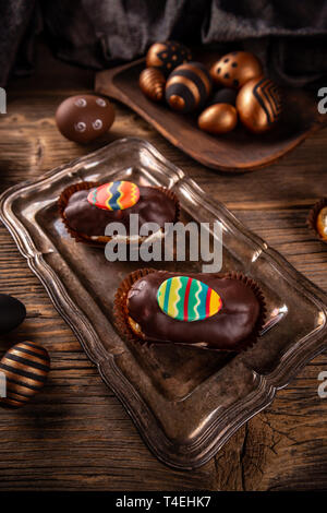 Pastry cream puff with chocolate ganache covering and Easter decoration Stock Photo