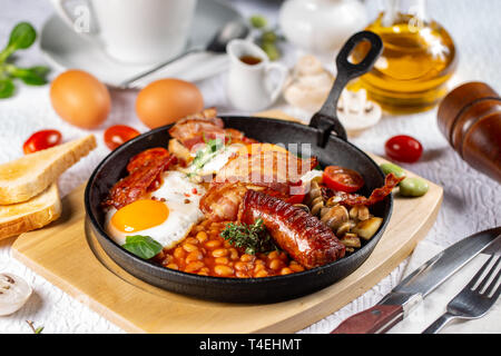 Traditional English breakfast with fried eggs, sausages, beans, mushrooms, grilled tomatoes and bacon Stock Photo