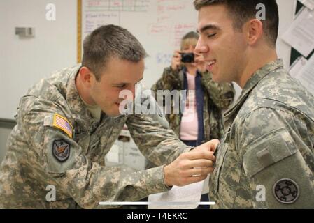 Staff Sgt. Daniel Sullivan, left, a broadcast journalist with the 372nd Mobile Public Affairs Detachment, promotes Spc. David Graves to the rank of sergeant, October, 2012, in Nashville, Tennessee. Sullivan and Graves, also with the 372nd MPAD 'Ghostwriters', have deployed three times together and also work together as camera men for a local news station in Nashville. Stock Photo