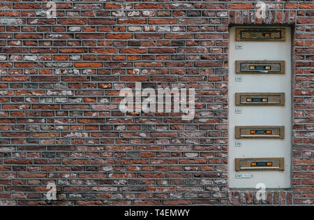 Mailbox slots on a industrial red brick wall background an old fashioned building. May be used in design and interiors. Stock Photo