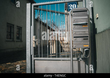 Metallic german letterboxes on gray fencing Stock Photo