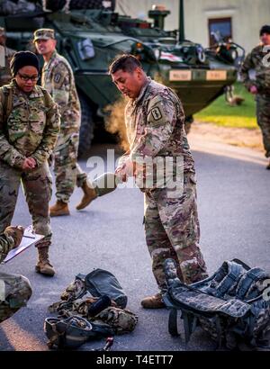 Steaming U.S. Army Capt. Ricardo Carino, assigned to the 212th Combat Support Hospital (CSH), passes his post ruck inspection and earns the EFMB on April 2, 2019. Stock Photo