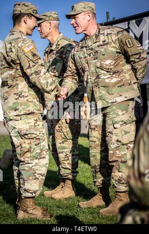 U.S. Army Command Sgt. Maj. Lee Ridling, Command Sgt. Maj. of the 421st Multifunctional Medical Battalion, congratulates Capt. Mark Doherty, assigned to the 212th Combat Support Hospital (CSH), on April 2nd, 2019. Stock Photo