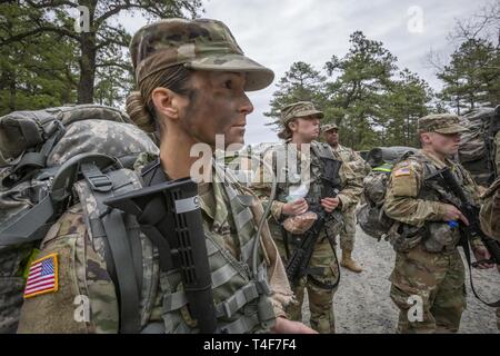 U.S. Army Sgt. Samantha L. Merryfield, left, 328th Military Police Company; Sgt. Karlee S. Severns, center, and Pfc. Matthew D. Maher, both with the Medical Detachment, listen to a safety briefing prior to the 12-mile ruck march – the final event of the New Jersey Army National Guard’s Best Warrior Competition at Joint Base McGuire-Dix-Lakehurst, N.J., April 11, 2019. Five Soldiers, one Airman, and three NCOs competed in the competition, which ran from April 8-11, 2019. The top Soldier and NCO will compete in the Region 1 Competition against National Guard Troops from the six New England state Stock Photo