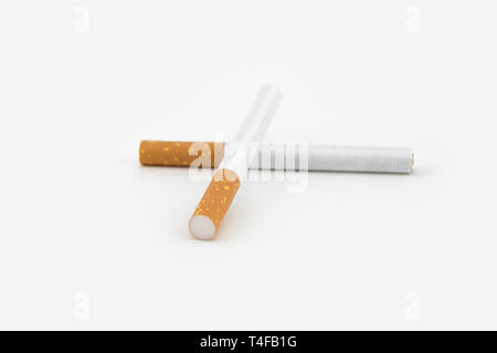 Two cigars isolated on white background. Filtered cigarettes. The tobacco can cause numerous damages to the organism. Stock Photo