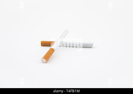Two cigars isolated on white background. Filtered cigarettes. The tobacco can cause numerous damages to the organism. Stock Photo