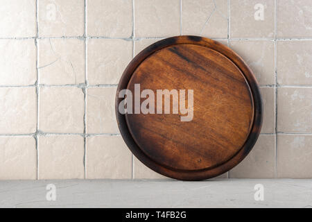 Cutting board on a kitchen background with ceramic tiles Stock Photo
