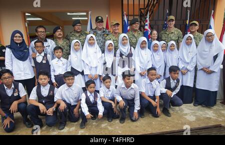 Malaysia (April 11, 2019) – Malaysian teachers and students take a group photo with Pacific Partnership 2019 leaders to commemorate a successful construction project during a ribbon cutting ceremony at Sambir Elementary School. These engagements promote cooperation and friendship between Pacific Partnership 2019 participants and the host nation. Pacific Partnership, now in its 14th iteration, is the largest annual multinational humanitarian assistance and disaster relief preparedness mission conducted in the Indo-Pacific. Each year the mission team works collectively with host and partner nati Stock Photo