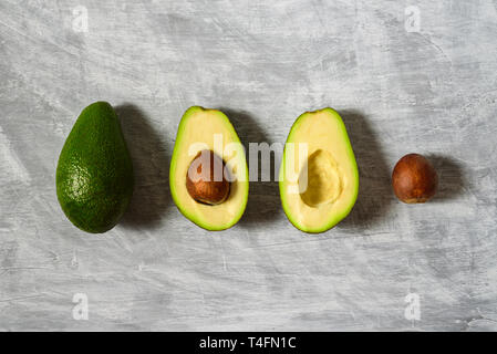 Avocado with half and seed on light grey background. Hard light Stock Photo