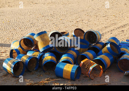 Colorful trash cans stacked on a sandy beach at the end of the season. Stock Photo