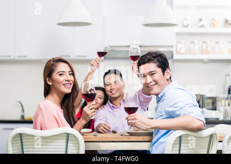 Portrait of happy friends holding red wine glasses Stock Photo