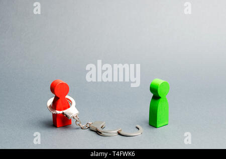 A man is bound by handcuffs standing near a free person. Exemption from debt or physical slavery. Parting or divorce of two persons. The end of the re Stock Photo
