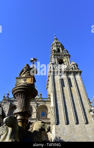 Cathedral, romanesque Platerias facade and baroque clock tower with stone horses fountain and blue sky. Santiago de Compostela, Spain. Stock Photo
