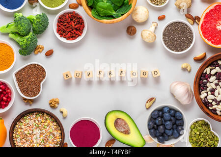 frame of superfood clean eating selection: fruit, vegetable, seeds, superfood, nuts, berries on white marble background. top view with copy space. veg Stock Photo