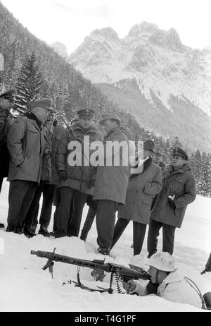 The Greek crown prince Konstantin of Greece visits the First Divison of German mountain troopers in Mittenwald on the 16th of January in 1963. The picture shows the crown prince of Greece (M) who receives explanations about a gun. In the foreground, a mountain trooper lies in the snow with a machine gun. | usage worldwide Stock Photo
