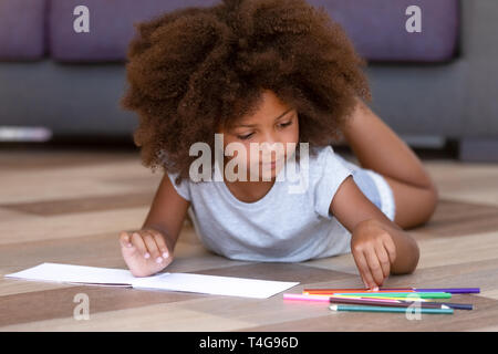 African American little girl playing, drawing with colored pencils Stock Photo