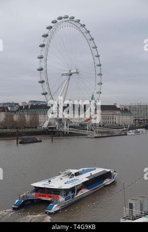 Water taxi sailing passed the London Eye on the Thames in winter Stock Photo