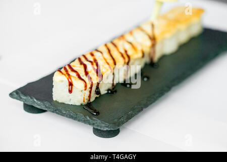 Putting sauce on uncut Japanese sushi roll Stock Photo