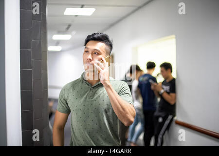 Asian handsome men talking happily on the phone | Guy smile while using smartphone Stock Photo
