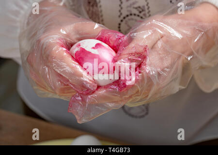 woman paint a egg made of polystyrene. Colorized acrylic egg Stock Photo