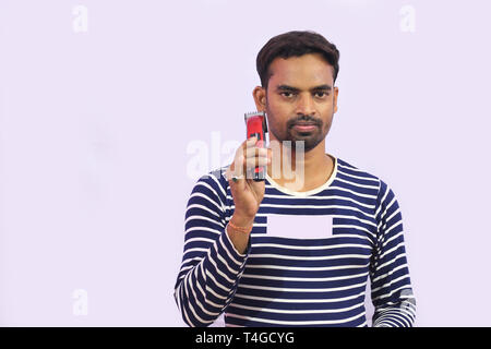 young man model holding a trimming machine with his hand with white isolated background Stock Photo