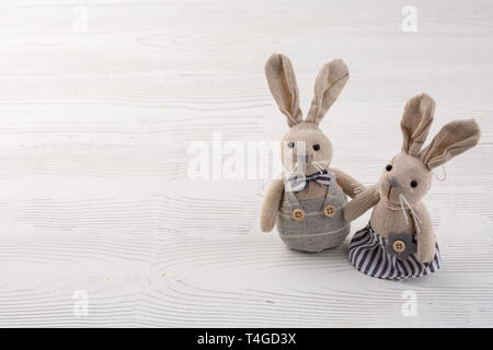 two white rabbits on white wooden background. couple cute Bunny toys. Easter bunnies decoration. Minimal Easter concept. Trendy creative photo. Copy s Stock Photo