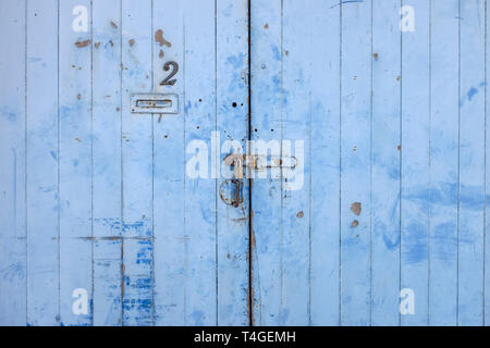 Painted pale blue wooden double garage doors with padlock Stock Photo