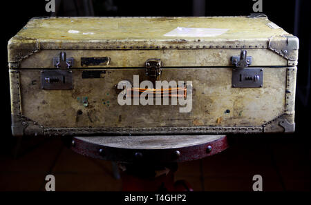 Close up of isolated old used suitcase with rivets, leather grip and combination locks Stock Photo