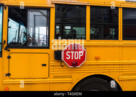 Bodywork and stop traffic sign of an old yellow school bus parked in Coney Island, New York City, USA Stock Photo