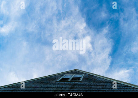 Triangular rooftop pointing toward a beautiful blue slightly cloudy sky, Block Island, RI Stock Photo